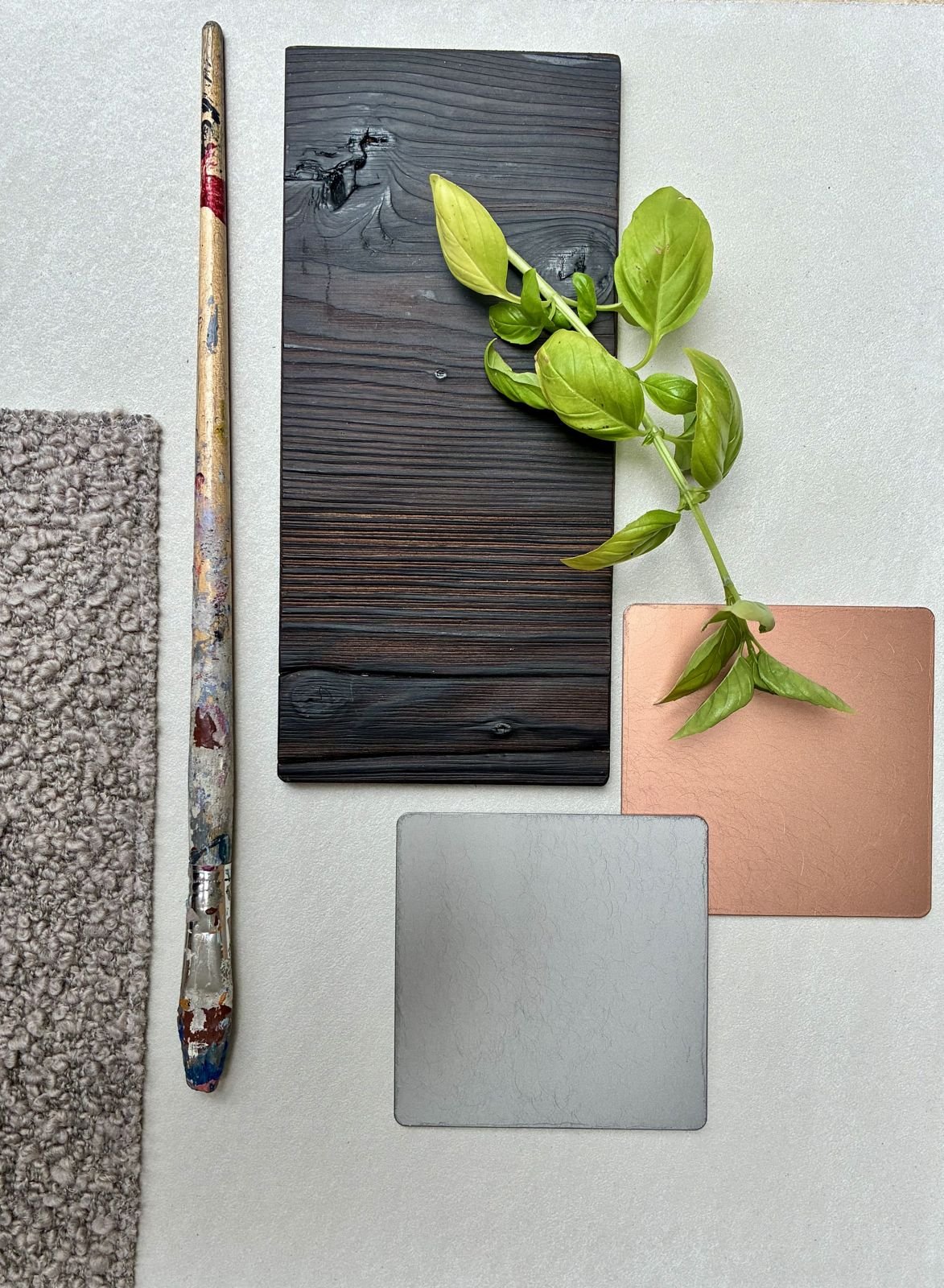 Planche de matières : bois brûlé, cuivre, acier brossé, bouclette grise