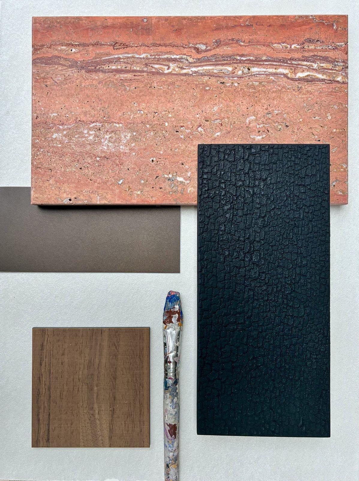 Planche de matières : travertin veiné, panneau texturé, métal bronze mat, noyer